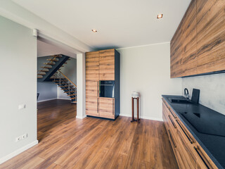 Interior of modern wooden kitchen with built-in appliances in house.