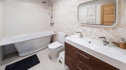 Modern interior of bathroom. White sink, toilet, bath. Tile floor.