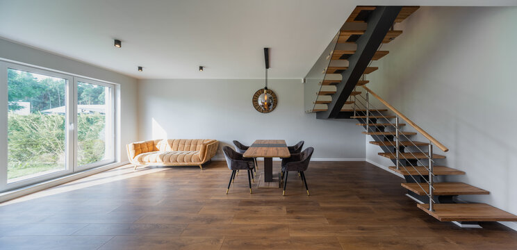 Modern interior of private house. Living room with table and chairs.