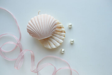 interior candle handmade from natural wax in the form of a shell on a white background