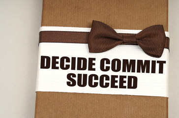 On the packing box with a bow-tie the inscription - Decide Commit Succeed