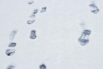 Footprints of a man on white snow in winter, winter background