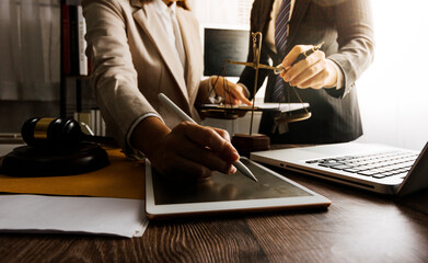 Business and lawyers discussing contract papers with brass scale on desk in office. Law, legal services, advice, justice and law concept