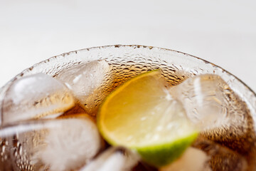 Alcoholic cocktail of rum with ice and lime, close-up, macro photography.