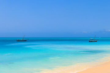 Obraz na płótnie Canvas View of tropical sandy Nungwi beach and traditional wooden dhow boats in the Indian ocean on Zanzibar, Tanzania