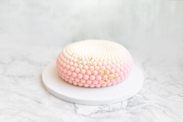 Interesting mousse cake on a white marble background. Delicious and beautiful pastries.