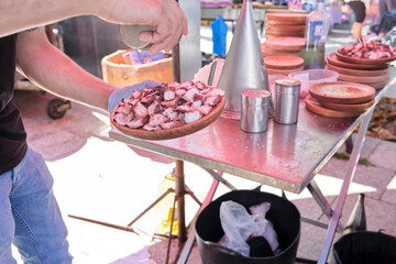 Unrecognizable man preparing a portion of the dish the traditional Galician octopus recipe,