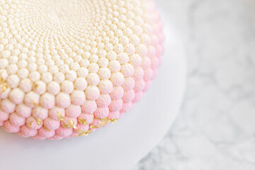 Interesting mousse cake on a white marble background. Delicious and beautiful pastries.