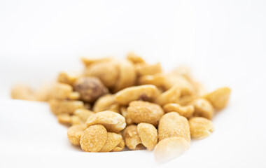 Close up of salted peanuts in white background.