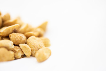 Close up of salted peanuts in white background.