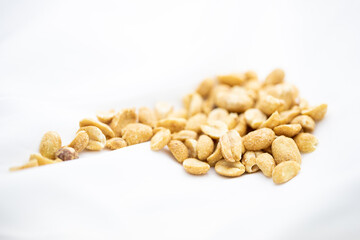 Close up of salted peanuts in white background.