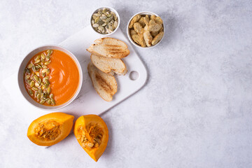Fototapeta na wymiar Bowl with vegetarian pumpkin cream soup with toast.