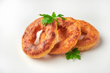 Oven baked or deep-fried breaded calamari rings over white backround