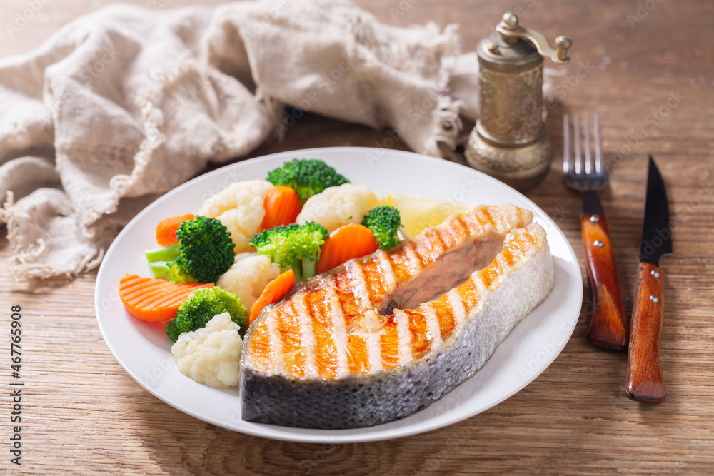 Sticker plate of grilled salmon steak with vegetables