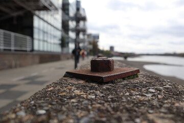 rusty metal bolt on built up bank of the River Thames in West London