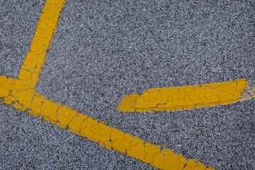 Street with yellow lines, coarse grey asphalt structure with different yellow painted marks, space for text, 