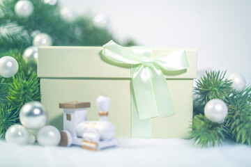 Green Gift box in Christmas. white Christmas Ball Ornaments and fir or pine tree branches.
