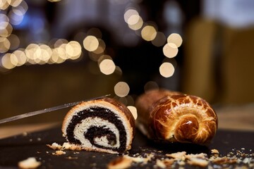 Close up image of poppy seed roll cake, traditional Christmas beigli on table at home, restaurant or patisserie.
