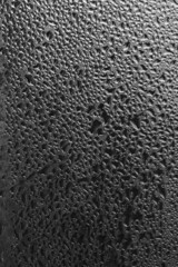Raindrops on the window pane on a gray background. Natural pattern of raindrops. Texture for creativity. Water on the surface of the glass.