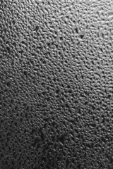 Raindrops on the window pane on a gray background. Natural pattern of raindrops. Texture for creativity. Water on the surface of the glass.