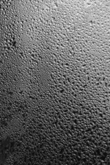 Raindrops on the window pane on a gray background. Natural pattern of raindrops. Texture for creativity. Water on the surface of the glass.