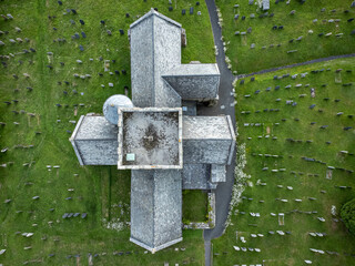 Drone top view of small old church at Avon cemetery. Gravestones on green grass in Avon Gifford St Andrew's Church Devon, UK. Drone aerial view