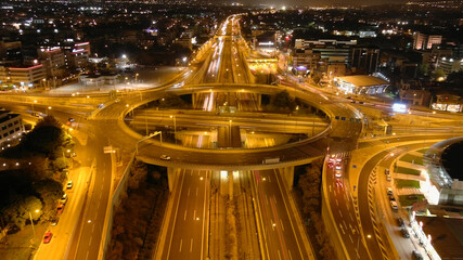 Fototapeta na wymiar Aerial drone night slow shutter shot of urban ring multilevel interchange highway road passing through city centre