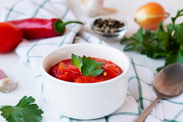 lecso national dish of Hungarian cuisine with pepper and tomato, greens on the white plate. lecho of tomatoes and sweet paprika with ingredients on the table. Hungarian food. copy space.