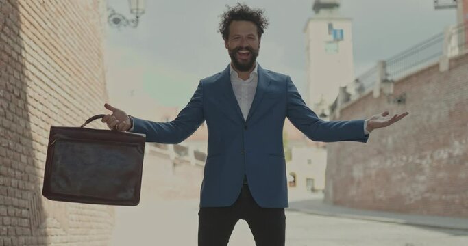 handsome businessman holding a briefcase, inviting us and being excited and laughing, outdoor