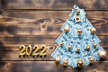 Christmas tree made of 100 dollar bills and House key, candles with the numbers 2022. Christmas...