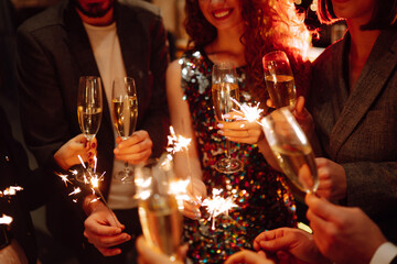 Sparkling sparklers in the hands. Playing firework to celebrate winter holidays with friends at the party. Magic New Year, Christmas.