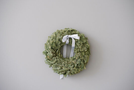 Green Pine Christmas wreath on gray wall with copy space