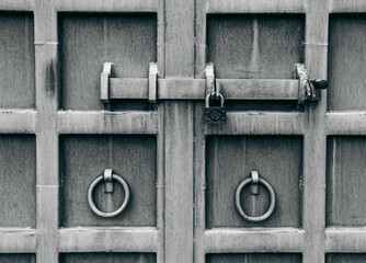 massive grey iron door with lock and heavy bolt, door handles in the form of rings