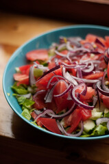 salad with tomatoes, cucumbers and red onions in a blue plate