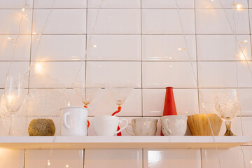 Light kitchen interior with red decor and Christmas tree decorations. Cooking a festive dinner at home