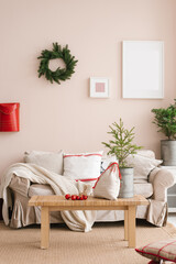 Stylish Christmas living room interior with sofa, coffee table, Christmas tree and wreath, mailbox, gifts and decorations. Festive time for the family.