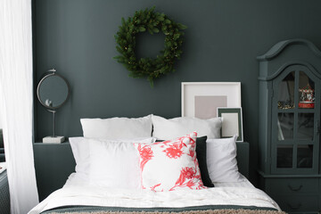 Christmas bedroom interior with a bed and a wreath above it in blue and white tones