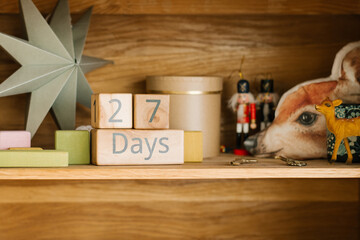 A perpetual calendar showing how many 27 days are left until Christmas or New Year and the decor on the shelf