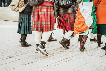 Legs of youth, friends in city street, Saint Patrick day parade, Irish national costumes