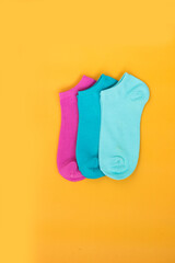 Three multicolored pairs of socks on a yellow background