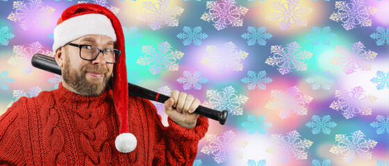 charismatic funny bearded young man in glasses, red wool sweater and red Santa hat is holding...