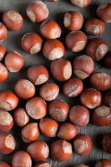 Food background with hazelnuts on a dark gray slate, stone or concrete table. Top view. Lots of nuts.Healthy various super food selection.