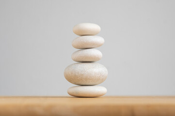 Fototapeta na wymiar Stone cairn on white background, five stones tower, simple poise stones, simplicity harmony and balance, rock zen