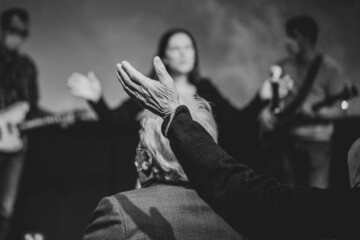 Old man rise his hand while he is praise God at church service - obrazy, fototapety, plakaty