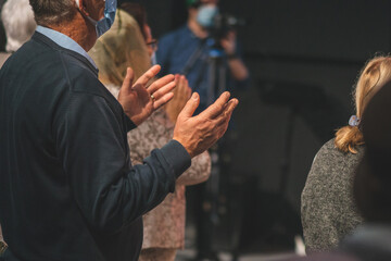 Old man rise his hand while he is praise God at church service