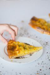 Georgian khachapuri with cheese and spices on the white plate on the white table