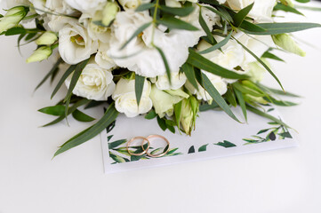 Wedding invitation with flowers and wedding rings