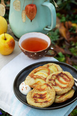 Whole wheat apple pancakes served with tea in the garden. Rustic style.