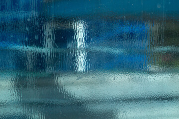 Blurred texture of transparent wet surface. Cold glass background.