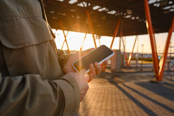 A man is holding a modern smartphone, sending a text message or using an application on his mobile phone. Business concept. Smartphone close-up. Focus on the phone screen